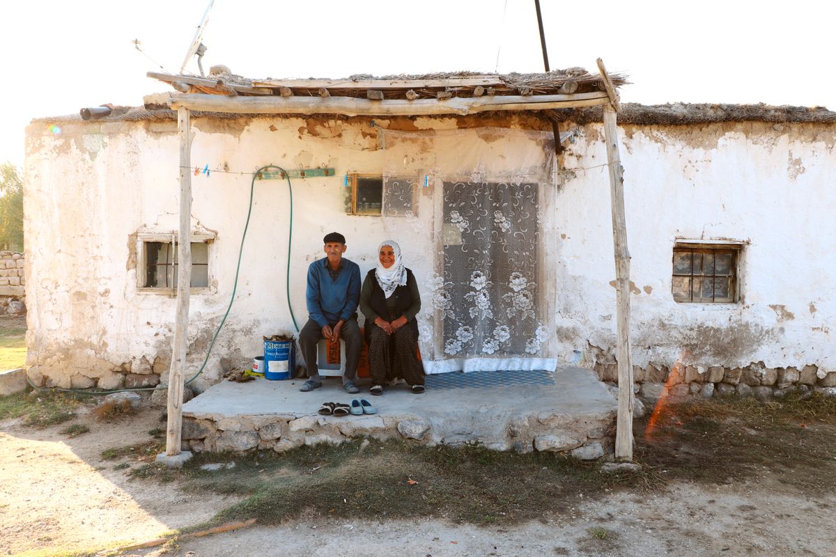 An older Utah couple sitting outside the home they own, considering whether to draw on their home equity in retirement.