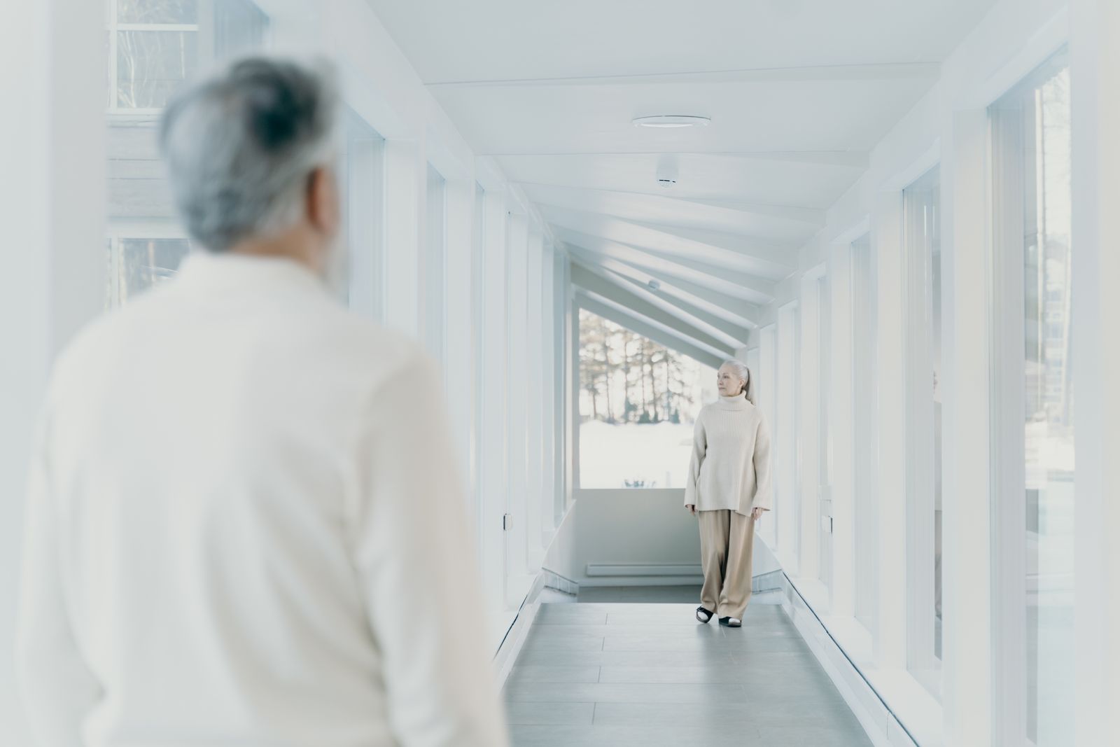 An older woman walking down a hallway at home with help — the outcome Utah's Medicaid home and community-based waivers are designed to make possible.