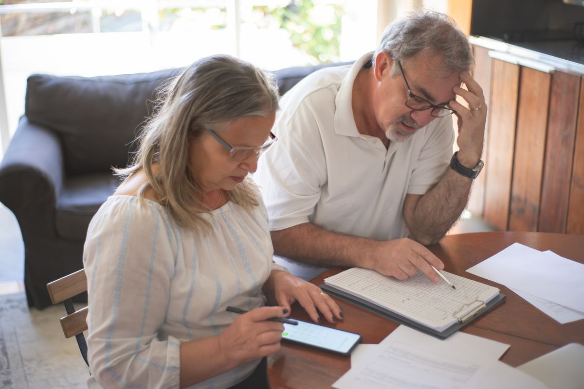 An older Utah couple at their kitchen table reading an insurance letter — the annual decision Utah's Medigap birthday rule creates on every policyholder's birthday.
